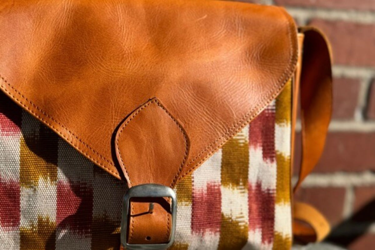 Close up of bag with checkered rust colored design and leather