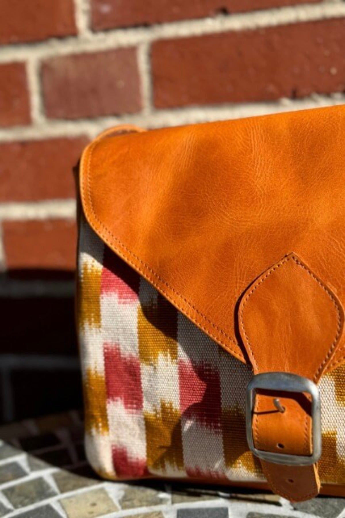 Crossbody bag with checkered rust colored design and genuine leather