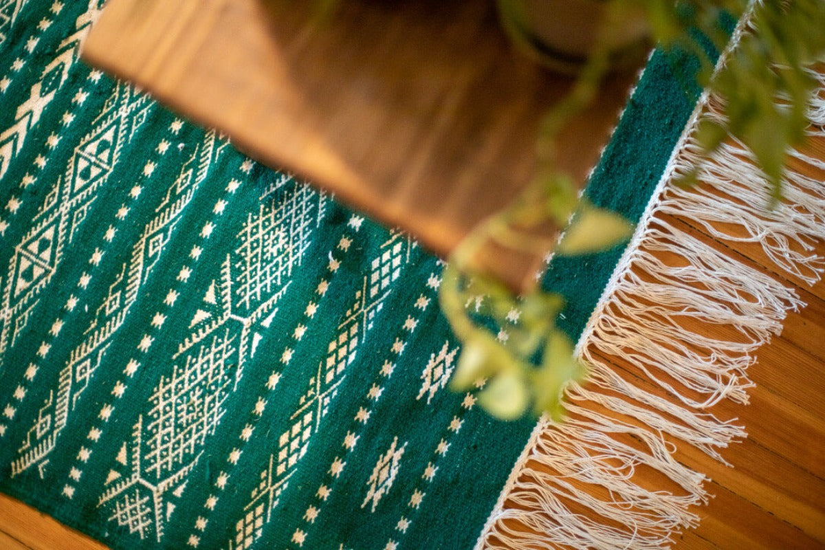 White geometric patterns on a green rug.