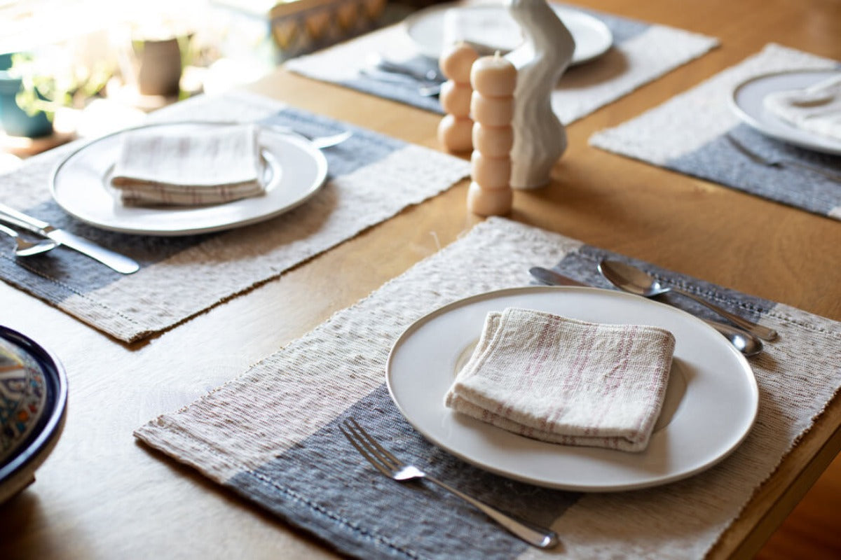 Table set for four with napkins, candles, and placemats