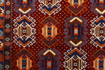 Red Kazak rug with blue and orange motifs.