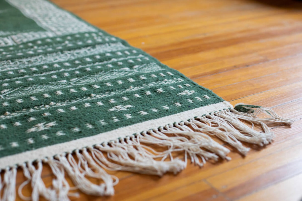 Green flatweave rug with long tassles