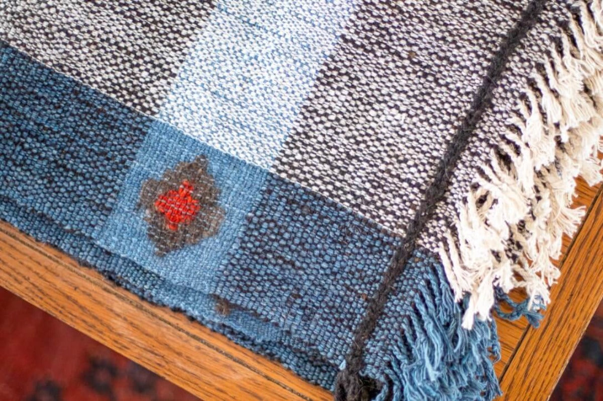 Close up of blue throw blanket with a red diamond motif