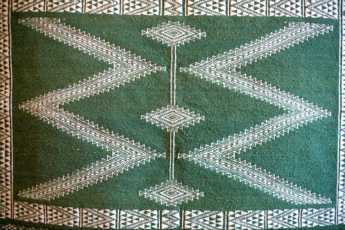 Green geometric motif on kilim rug