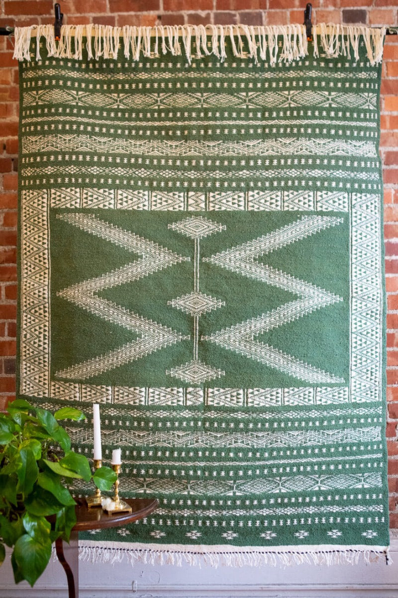 Wool kilim rug with white patterns on green background