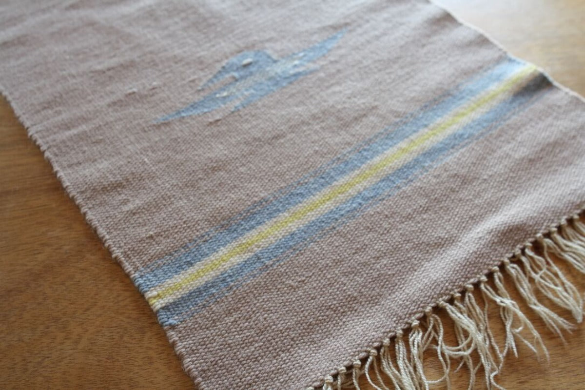 Woven table runner with bird and stripes