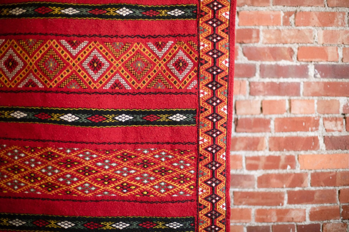 Close up of red rug with geometric patterns