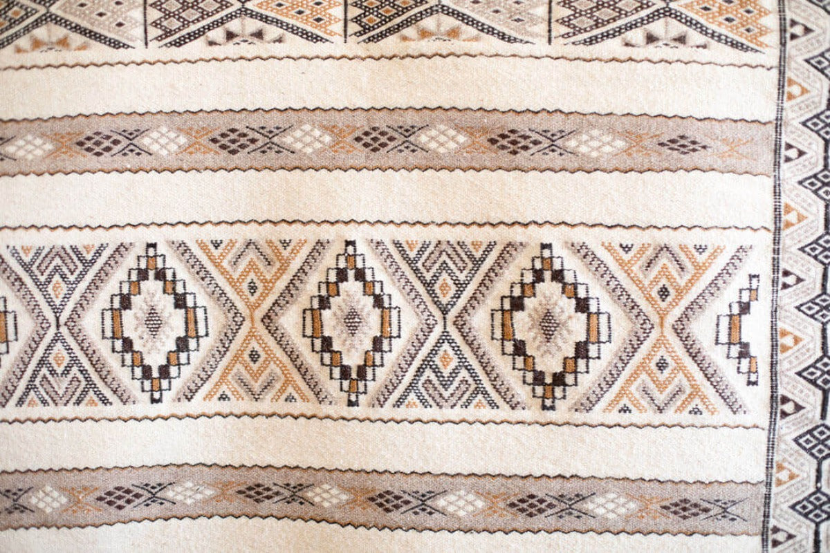 Close up of white rug with geometric diamond pattern